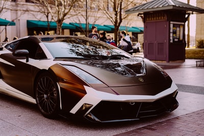 White and black lamborghini avenue parked in the street during the day
